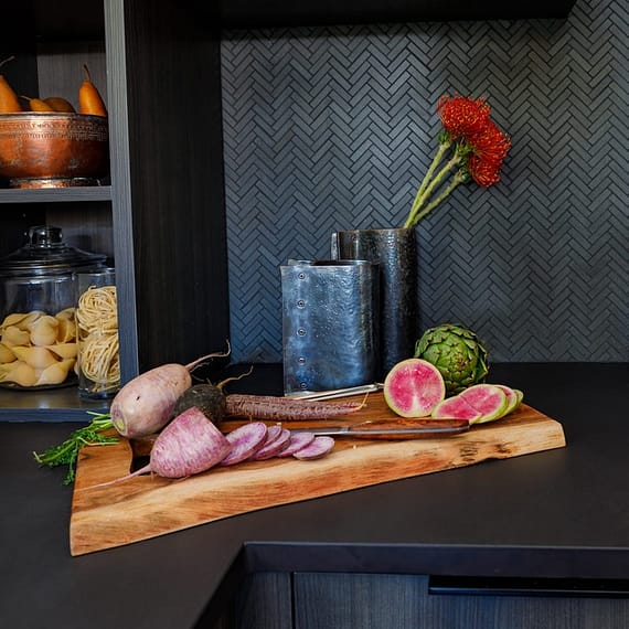 Stoneware with chopped veggies on a dark countertop.